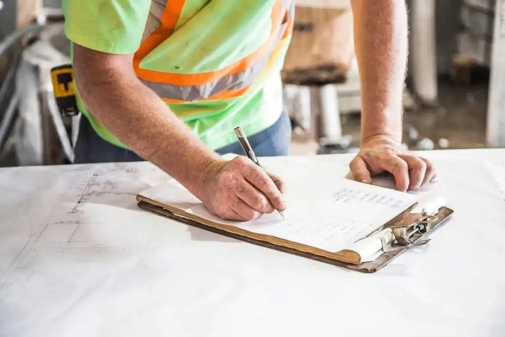 Contractor reviewing plans on a clipboard